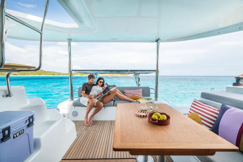 Slide: The Image of Couple relaxing on Lagoon 38 catamaran, 2026 model, with ocean view and cozy seating. - 3