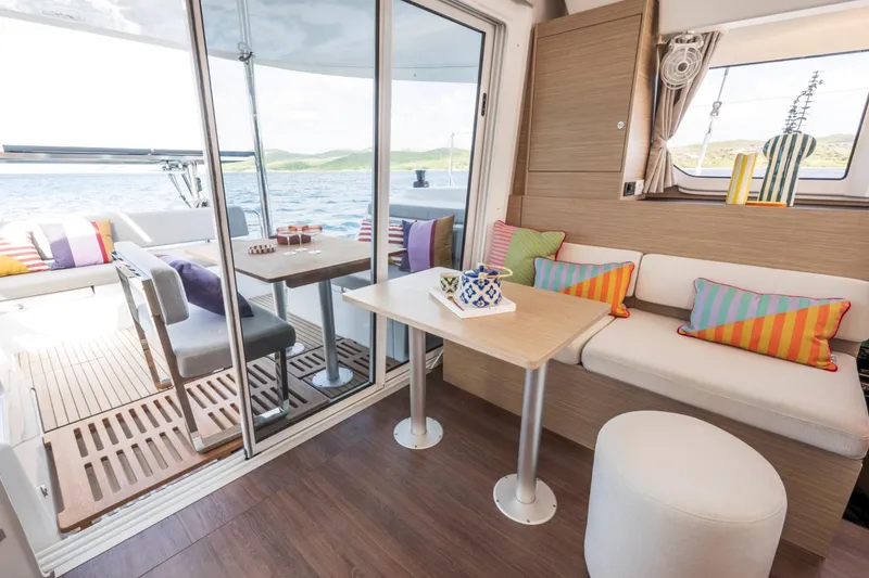 Slide: The Image of Modern interior of 2026 Lagoon 38 catamaran with colorful cushions and ocean view. - 9