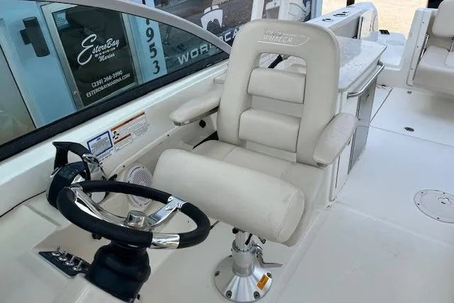 Slide: The Image of 2018 Boston Whaler 270 Vantage helm with white captain's chair and steering wheel. - 6