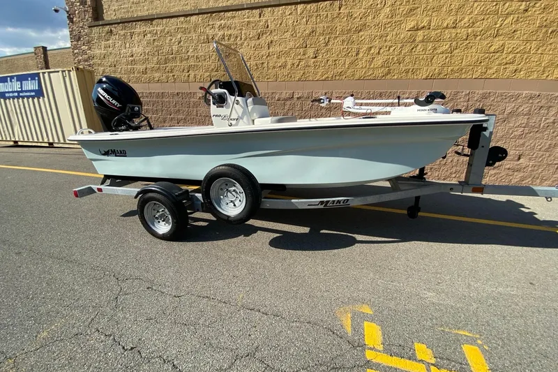 Slide: The Image of 2025 Mako Pro Skiff 13 CC boat on trailer, parked outdoors. - 1