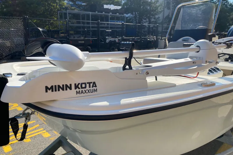 Slide: The Image of 2025 Mako Pro Skiff 13 CC with Minn Kota Maxxum trolling motor, docked outdoors. - 4