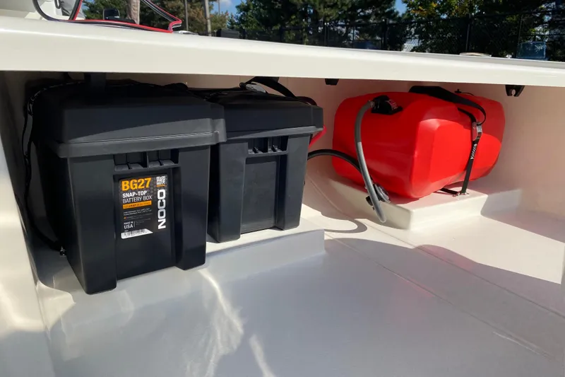 Slide: The Image of 2025 Mako Pro Skiff 13 CC storage with battery boxes and red fuel tank. - 5