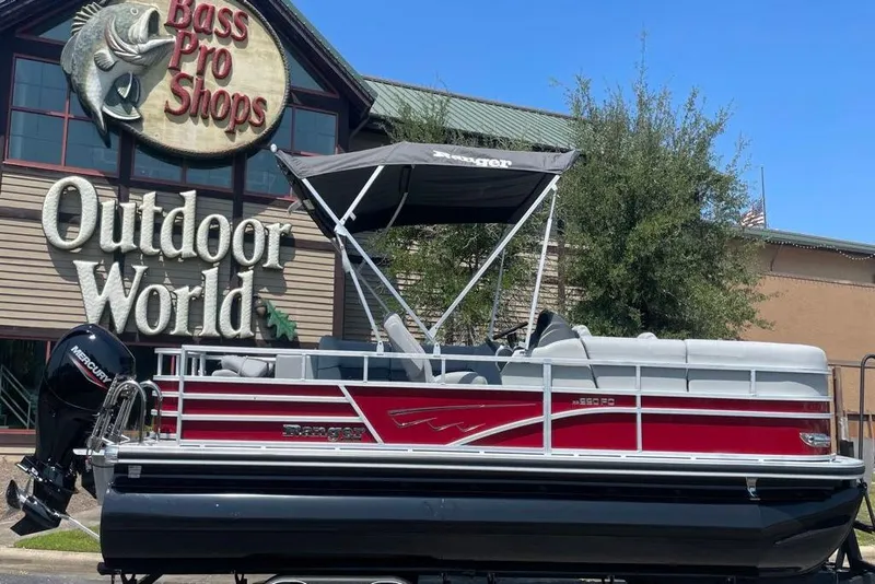 The Image of 2025 Ranger Reata 220FC pontoon boat displayed outside Bass Pro Shops. - 0