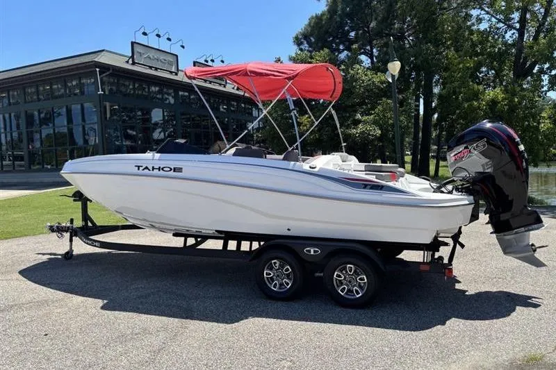 The Image of 2026 Tahoe T21 boat with red canopy on trailer, parked outdoors near showroom. - 0