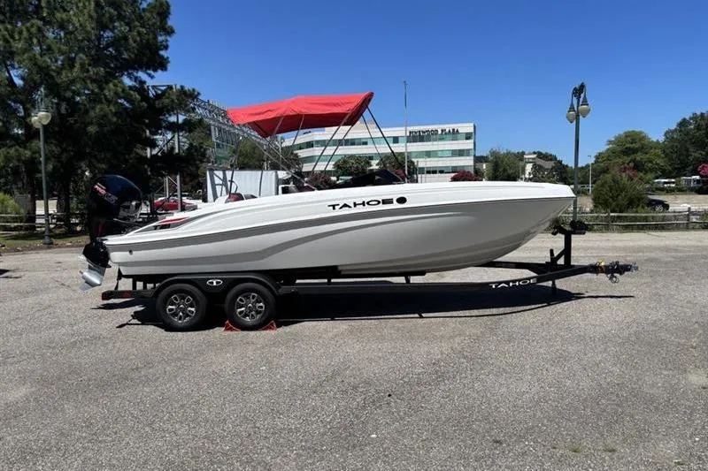 Slide: The Image of 2026 Tahoe T21 boat on trailer with red canopy, parked outdoors under clear blue sky. - 5