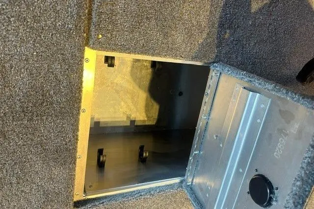 Slide: The Image of Open storage compartment in 2026 Tracker Pro 170 boat, featuring carpeted interior. - 8