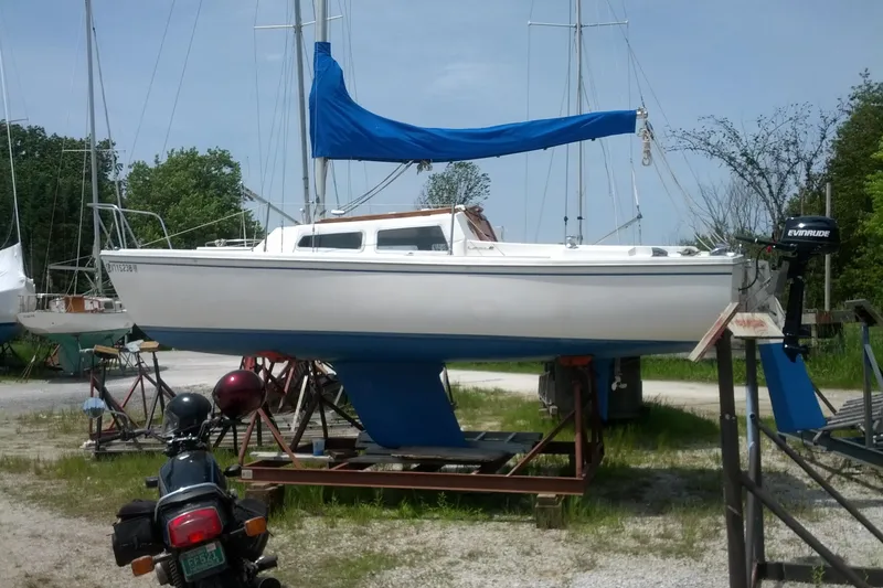 Slide: The Image of 1981 Catalina 22 sailboat with blue sail cover on a trailer, parked outdoors. - 2