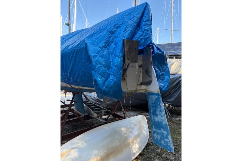 Slide: The Image of 1981 Catalina 22 sailboat covered with blue tarp, stored on a trailer. - 22
