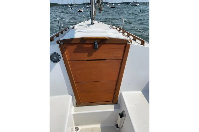 Slide: The Image of 1981 Catalina 22 sailboat cockpit with wooden hatch, docked on a calm lake. - 4