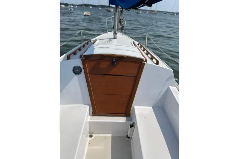Slide: The Image of 1981 Catalina 22 sailboat cockpit with wooden hatch, moored on a calm lake. - 6