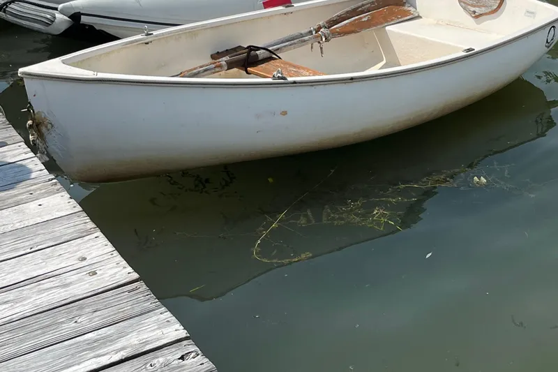 Slide: The Image of White Catalina 22 sailboat from 1981 docked on calm water. - 8