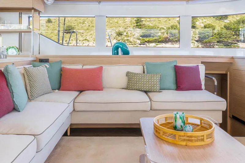 Slide: The Image of Luxurious Lagoon 60 yacht interior, 2026 model, featuring elegant seating and vibrant cushions. - 11