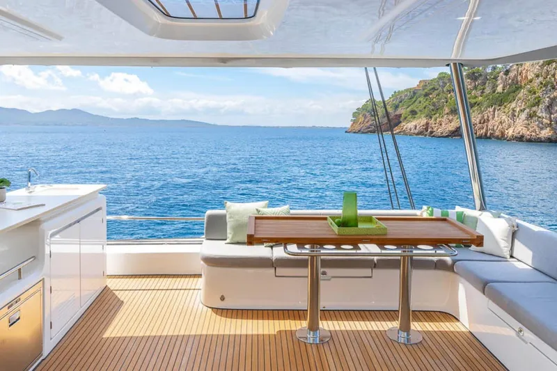 Slide: The Image of Luxurious Lagoon 60 yacht interior with ocean view, featuring modern seating and dining area, 2026 model. - 17