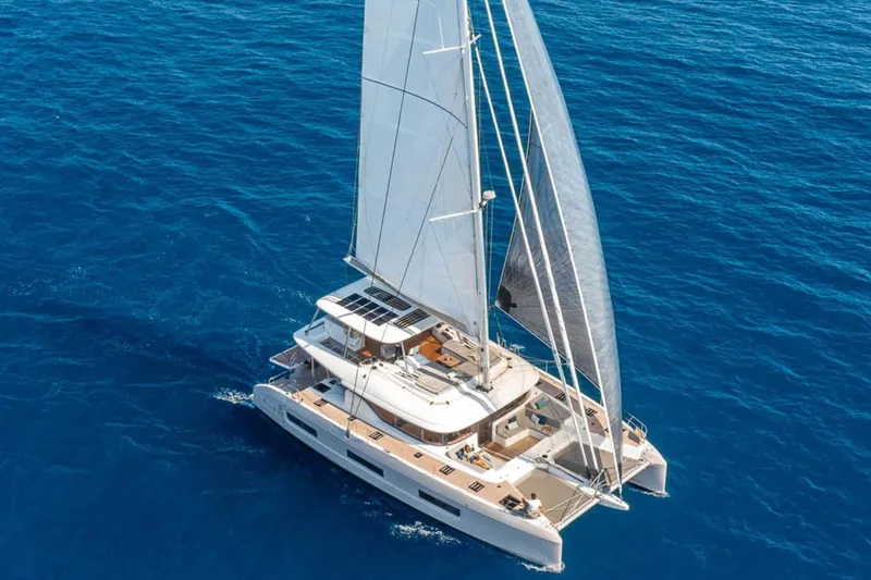 Slide: The Image of 2026 Lagoon 60 catamaran sailing on open blue sea. - 2