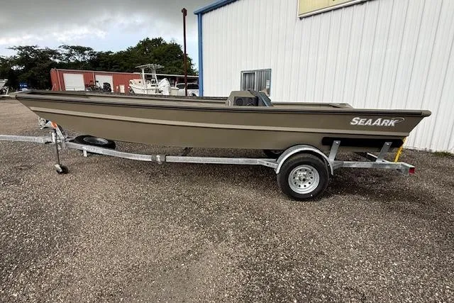 The Image of 2025 SeaArk 1860 MV boat on trailer with Suzuki outboard motor, parked outdoors. - 0