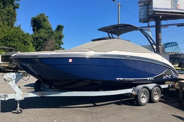 The Image of 2016 Yamaha Boats AR240 on trailer, blue hull, covered, parked outdoors. - 0