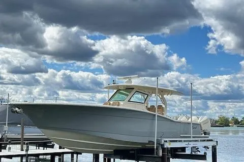 The Image of 2019 Scout 355 LXF boat docked under cloudy sky. - 1