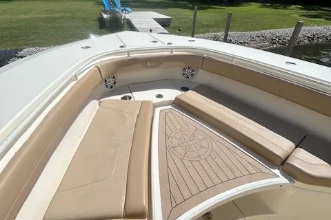 Slide: The Image of 2019 Scout 355 LXF boat interior with beige seating and wood accents. - 20