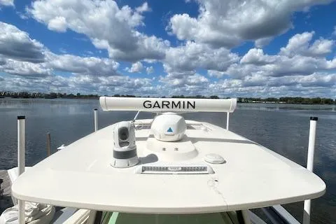Slide: The Image of 2019 Scout 355 LXF boat with Garmin equipment on a calm lake under a cloudy sky. - 25