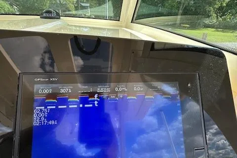 Slide: The Image of 2019 Scout 355 LXF boat dashboard with GPS display and scenic view. - 32