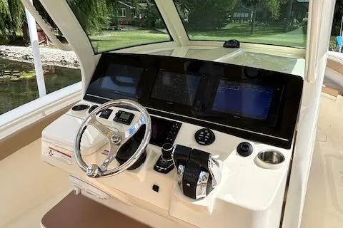 Slide: The Image of 2019 Scout 355 LXF boat dashboard with steering wheel and navigation screens. - 34