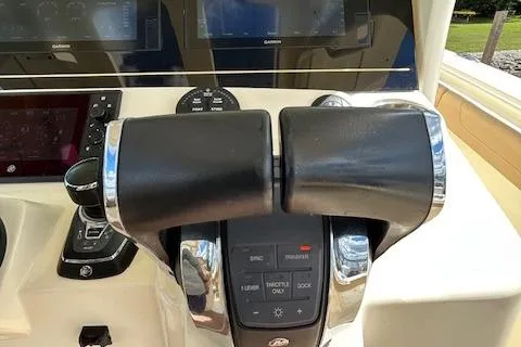 Slide: The Image of Throttle controls on a 2019 Scout 355 LXF boat dashboard. - 36