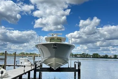 Slide: The Image of 2019 Scout 355 LXF boat docked under a cloudy blue sky. - 4