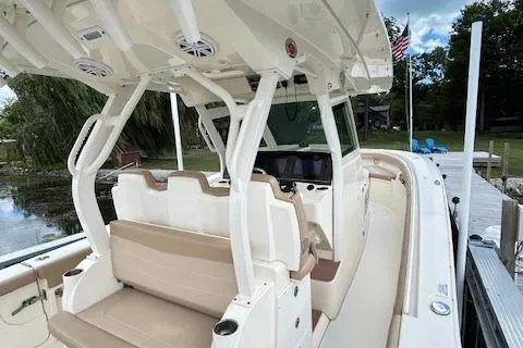 Slide: The Image of 2019 Scout 355 LXF boat interior with seating and helm, docked by a lake. - 41
