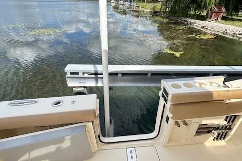 Slide: The Image of 2019 Scout 355 LXF boat docked by a serene lake with clear water. - 46