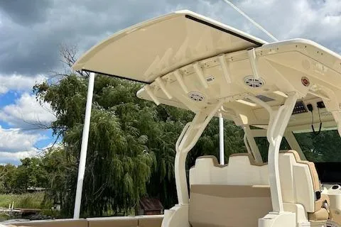 Slide: The Image of 2019 Scout 355 LXF boat with sleek design and modern features, under a cloudy sky. - 53