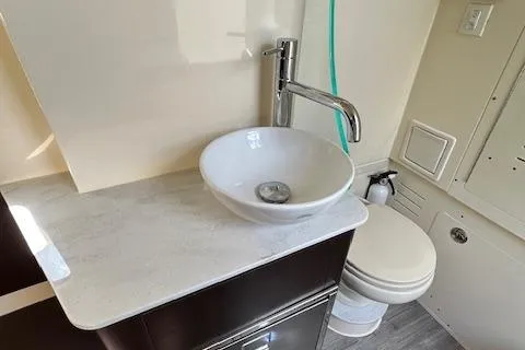 Slide: The Image of 2019 Scout 355 LXF boat bathroom with modern sink and toilet. - 55