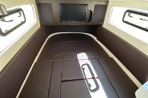 Slide: The Image of 2019 Scout 355 LXF cabin interior with brown cushioned seating and windows. - 56