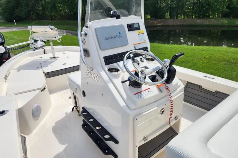 Slide: The Image of 2024 Pathfinder 2200 TRS boat console with Garmin navigation, steering wheel, and controls. - 12