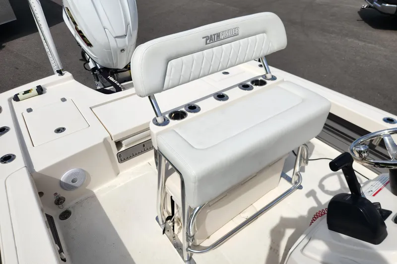 Slide: The Image of 2024 Pathfinder 2200 TRS boat interior with white seating and steering console. - 13