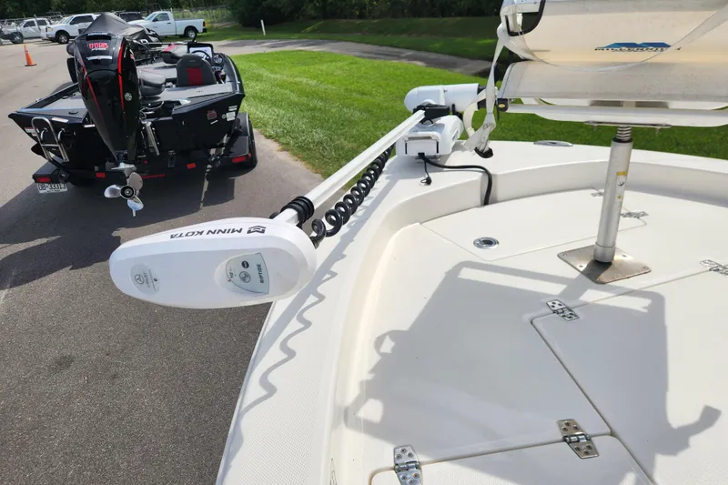 Slide: The Image of 2024 Pathfinder 2200 TRS boat with Minn Kota trolling motor, parked on a sunny day. - 8