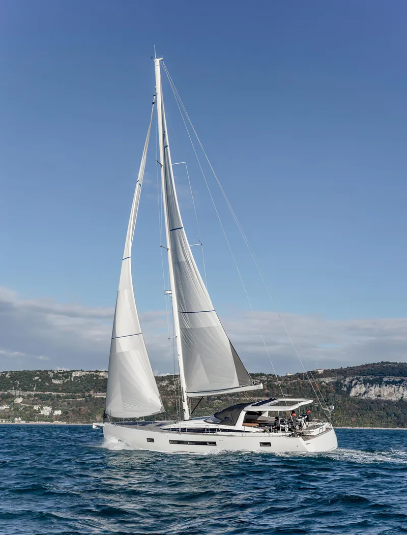 Slide: The Image of 2026 Jeanneau 65 sailing yacht on open water under clear blue sky. - 4