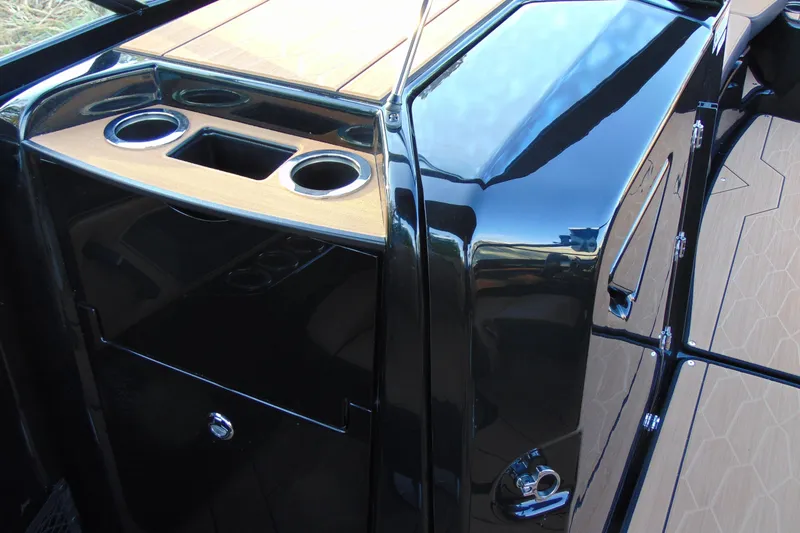 Slide: The Image of 2026 Yamaha Boats 255XD interior with sleek black finish and cup holders. - 14