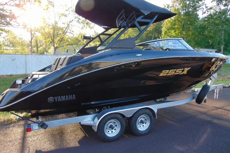 Slide: The Image of 2026 Yamaha Boats 255XD in black on a trailer, parked outdoors. - 3