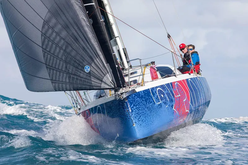 Slide: The Image of 2026 Jeanneau Sun Fast 3300 sailing on rough seas with crew onboard. - 1