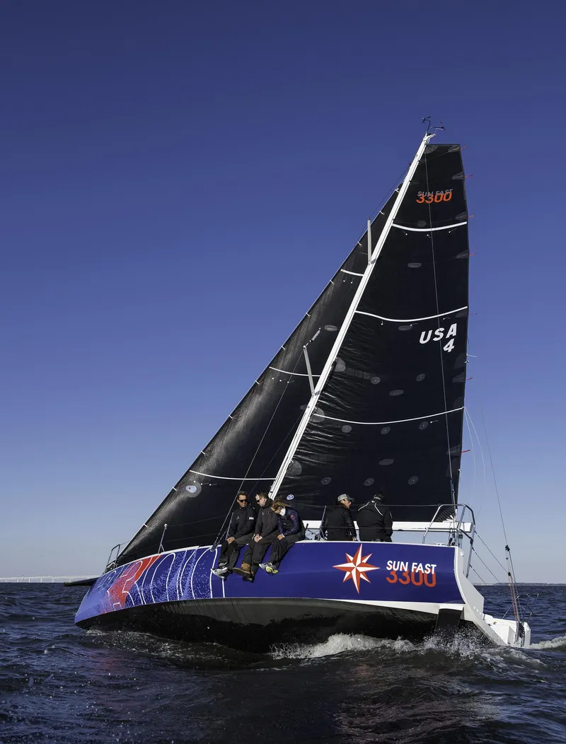 Slide: The Image of 2026 Jeanneau Sun Fast 3300 sailboat on open water under clear blue sky. - 2