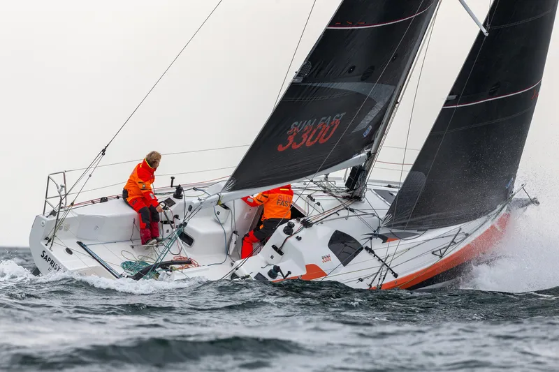 Slide: The Image of 2026 Jeanneau Sun Fast 3300 sailing in rough waters with crew in orange gear. - 5