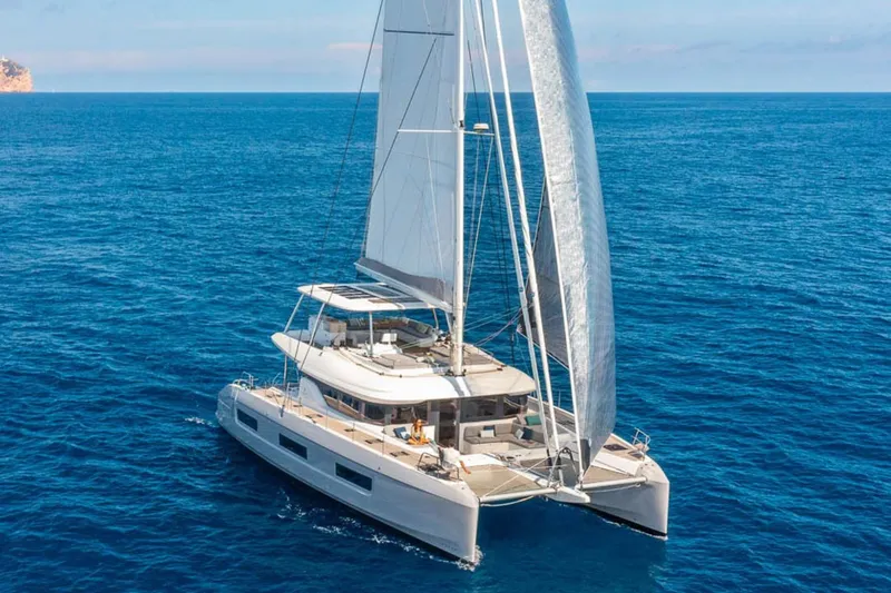 Slide: The Image of 2026 Lagoon 60 catamaran sailing on open blue sea. - 24