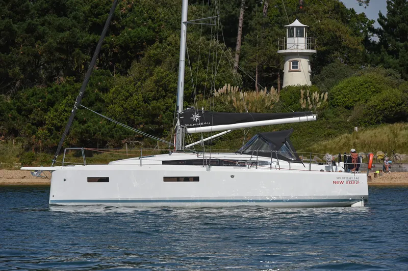 Slide: The Image of 2026 Jeanneau Sun Odyssey 380 sailboat on water near a lighthouse and trees. - 4