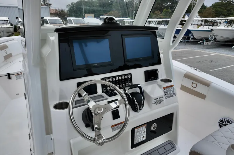 Slide: The Image of 2026 Sea Fox 288 Commander boat dashboard with dual screens and steering wheel. - 12