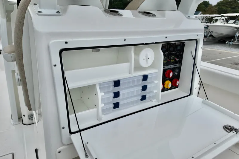 Slide: The Image of 2026 Sea Fox 288 Commander boat storage compartment with tackle boxes and control panel. - 13