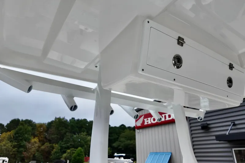 Slide: The Image of 2026 Sea Fox 288 Commander boat storage compartment and rod holders, outdoor setting. - 23