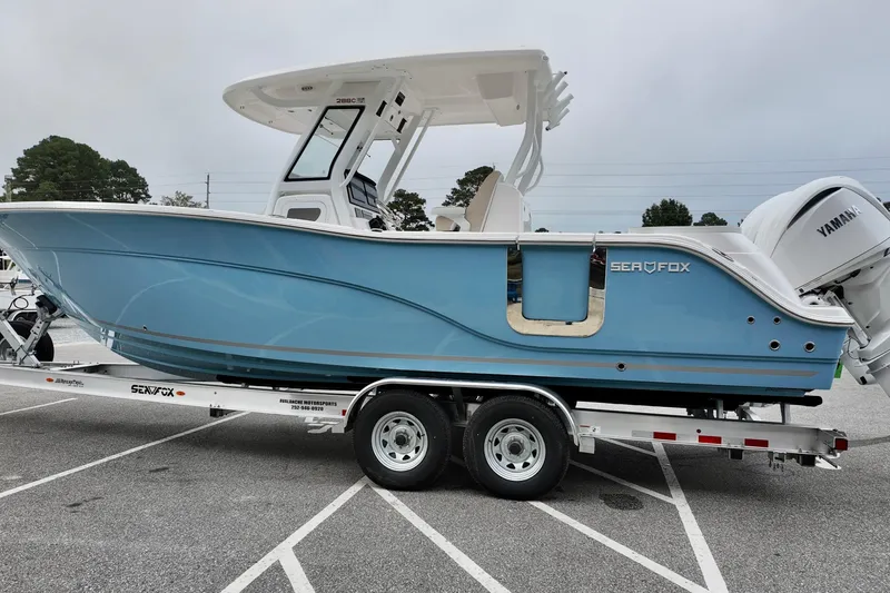 Slide: The Image of 2026 Sea Fox 288 Commander boat on trailer, side view, blue hull. - 3