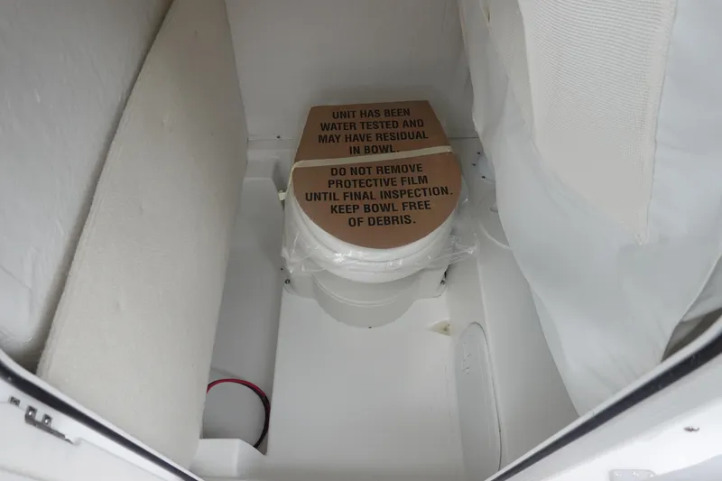 Slide: The Image of 2026 Sea Hunt Ultra 245 SE boat toilet with protective film and inspection notice. - 28