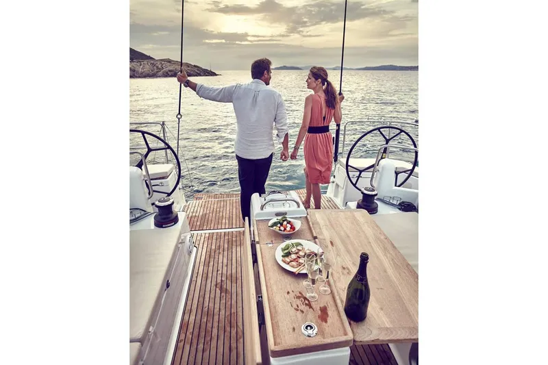 Slide: The Image of Couple enjoying sunset on Jeanneau Sun Odyssey 490 yacht, 2026 model, with dining setup. - 15