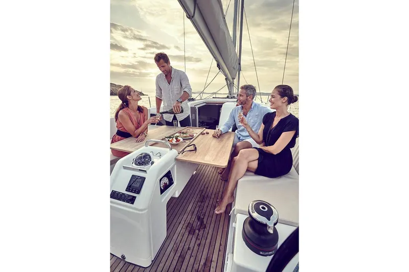 Slide: The Image of Four people enjoying a meal on a 2026 Jeanneau Sun Odyssey 490 sailboat. - 16